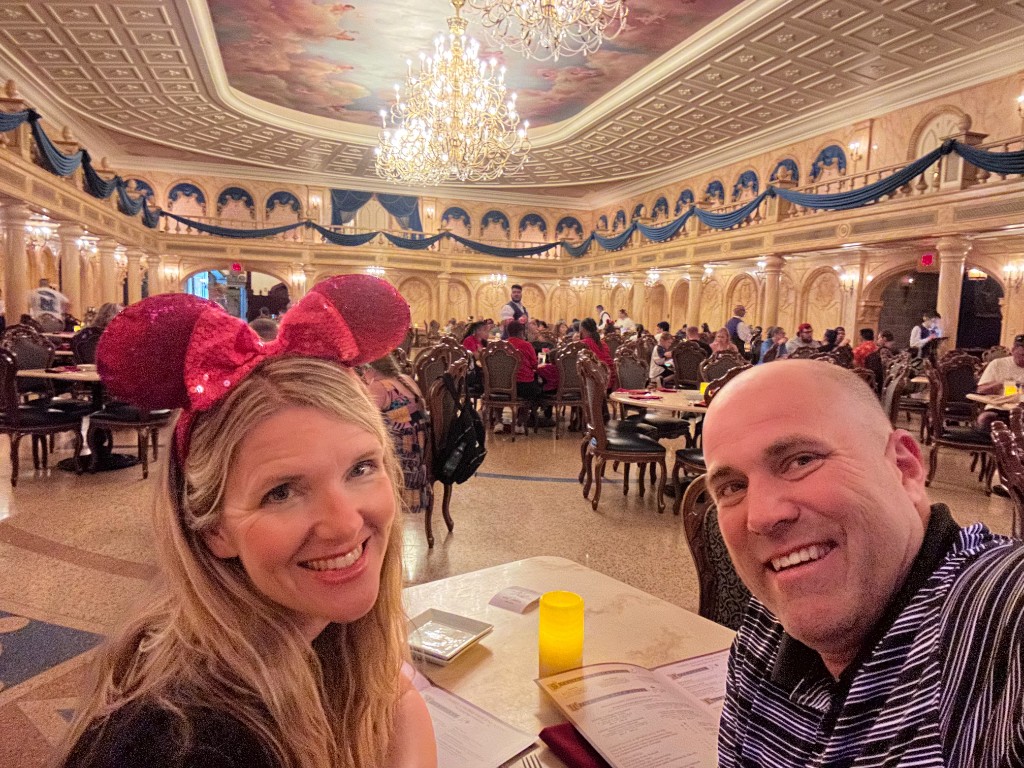 Ryan and Sarah in the Be Our Guest ballroom under the chandelier