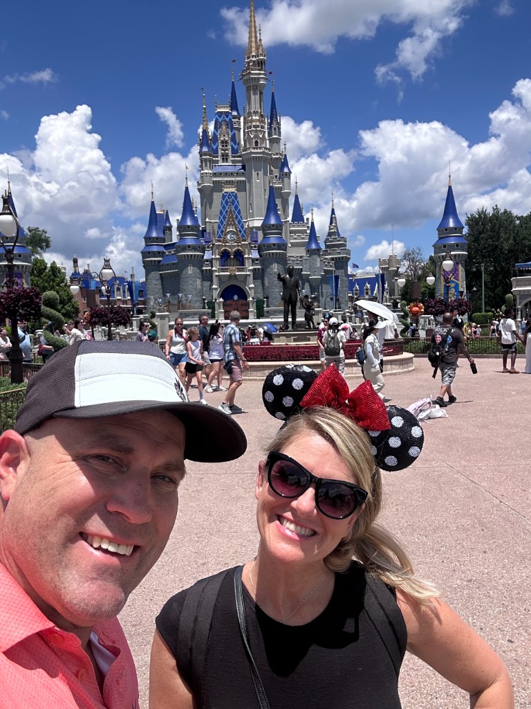 Ryan and Sarah in front of Cinderella Castle on their anniversary