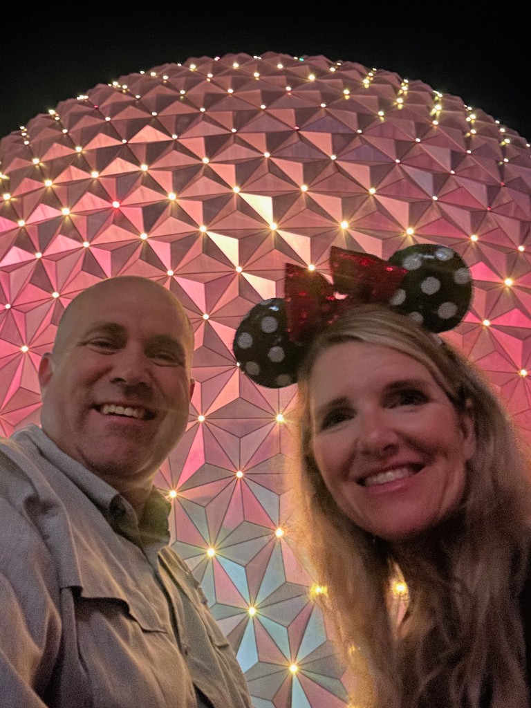 Ryan and Sarah in front of Spaceship Earth lit at night