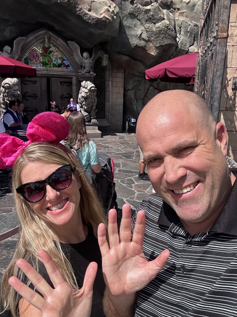 Ryan and Sarah ranking selfie outside Be Our Guest