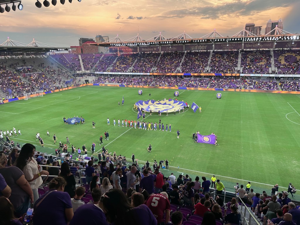 Pre-match ceremony with the lion logo banner at sunset