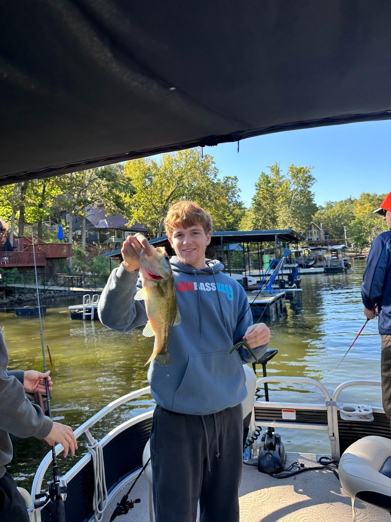 Bryce holding a bass in a Big Bass Bash hoodie