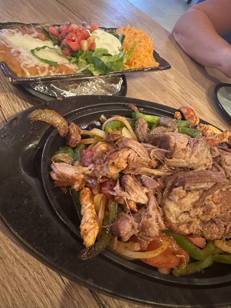 Fajita skillet with chicken, steak, and pork plus rice, beans, and salad