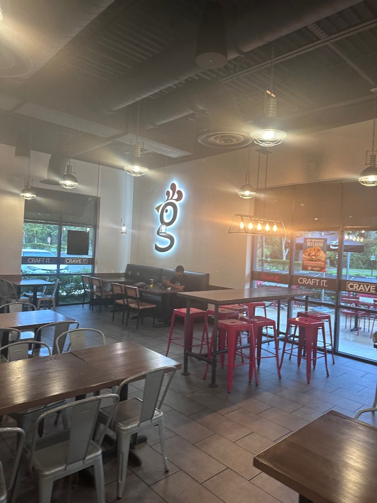 Dining room at Huey Magoo's Lake Nona with neon chicken sign