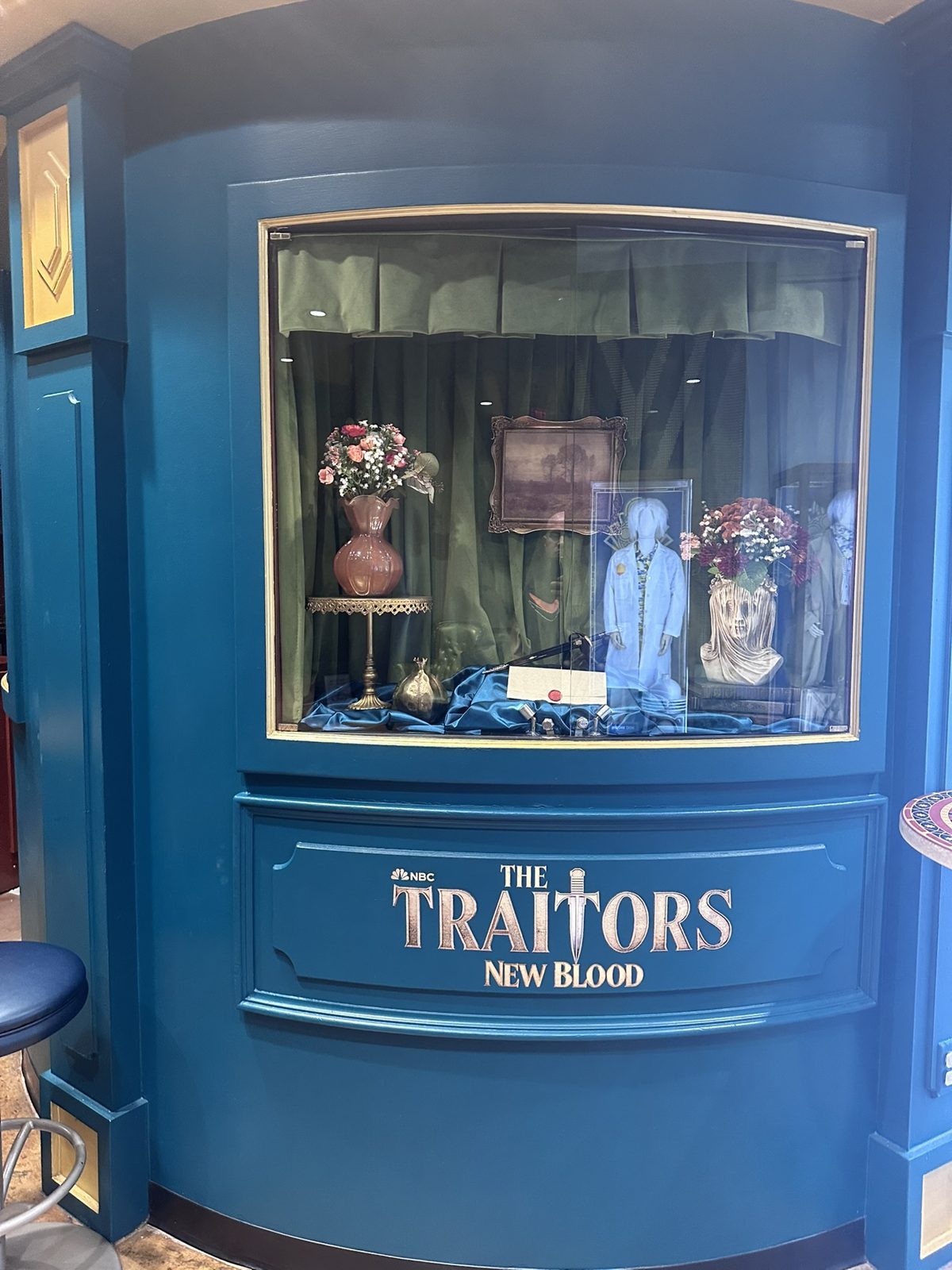 The Traitors: New Blood display case with props and a sealed envelope