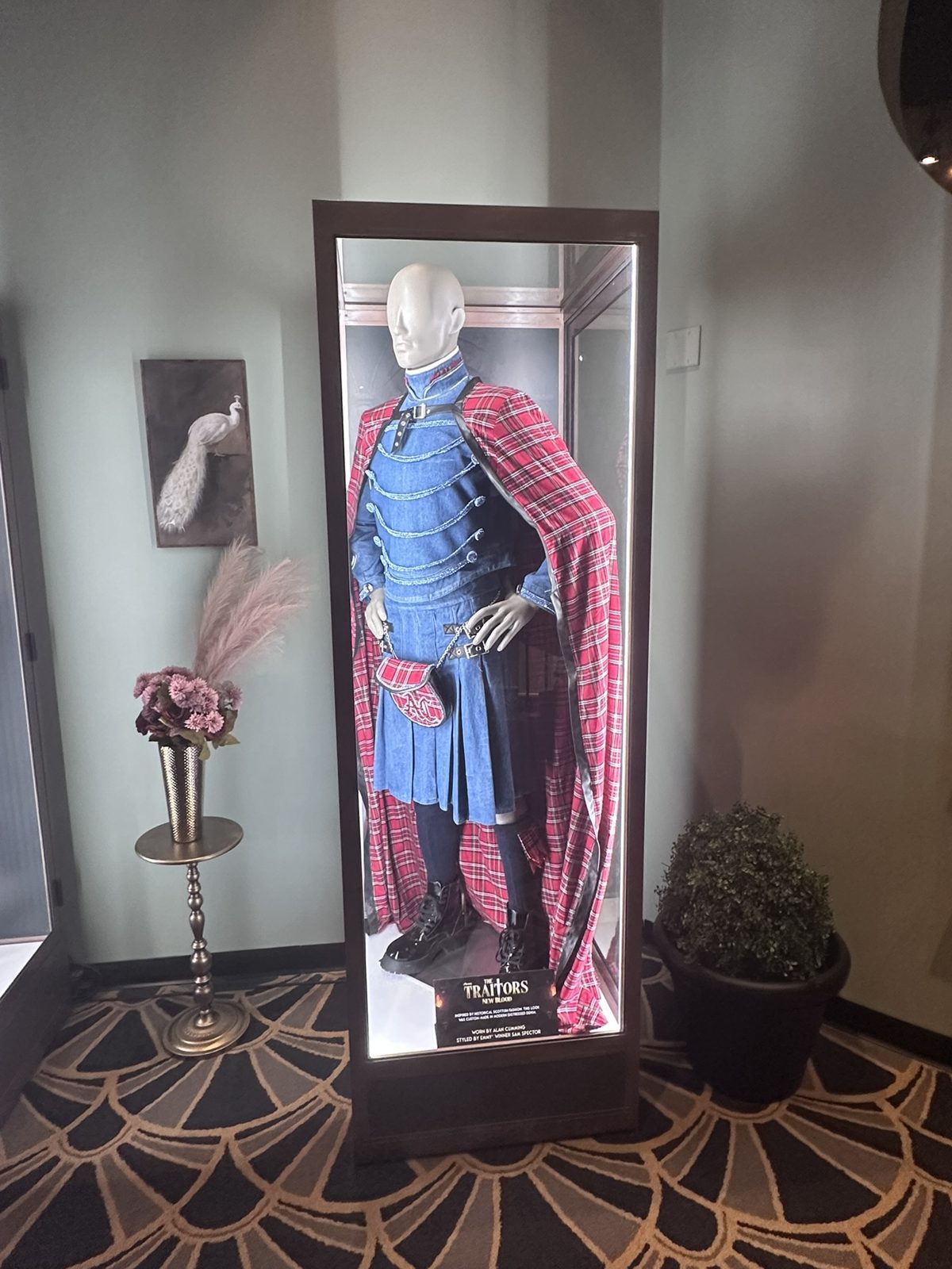 Denim and red tartan outfit worn by host Alan Cumming in a display case
